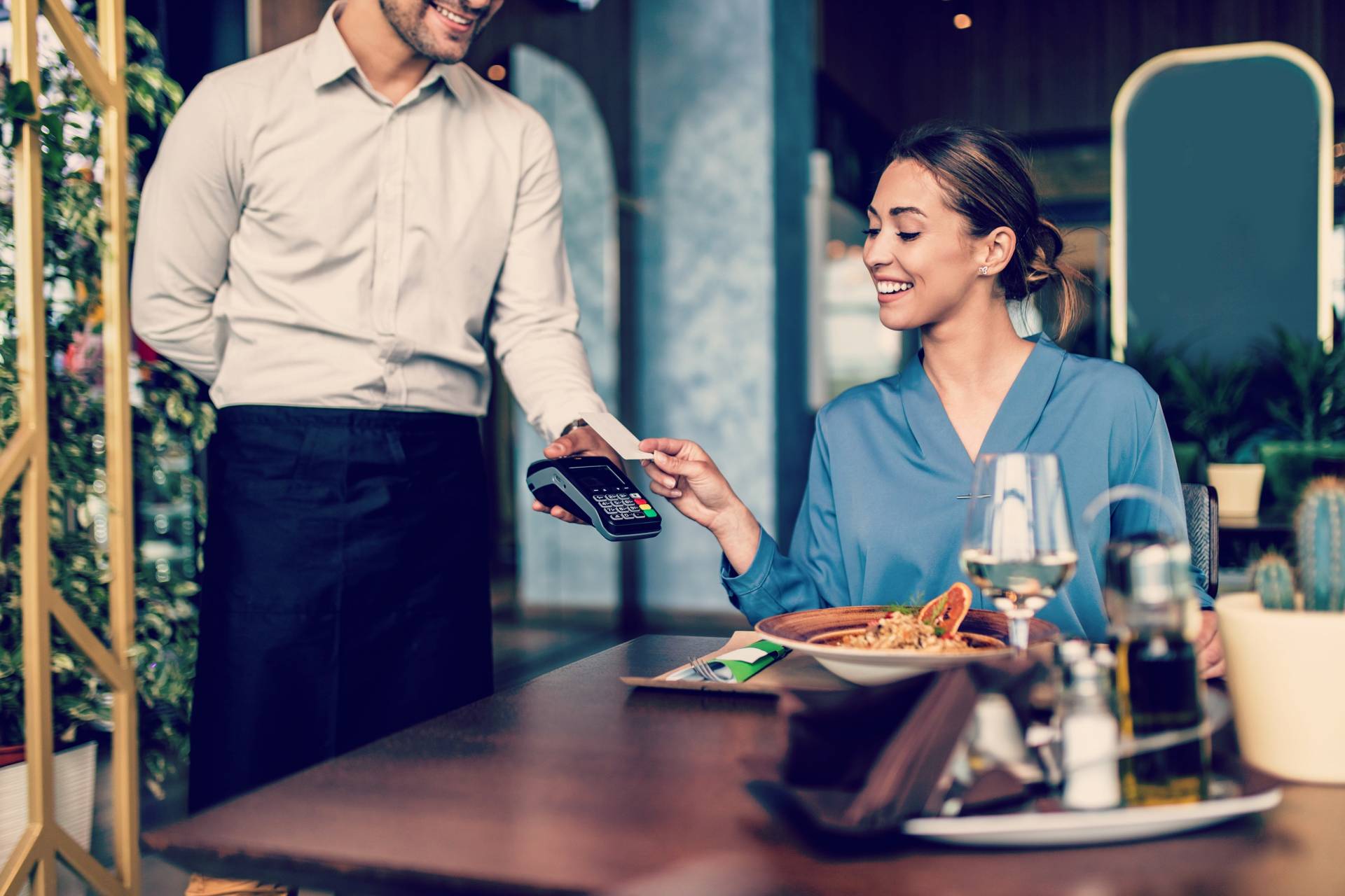 Kobieta płacąca kartą w restauracji